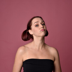 Naklejka premium close up portrait of red haired women with different facial expressions on a pink studio background.