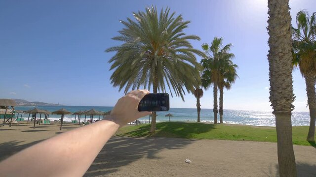 Man taking picture of beach in Malaga in Spain in 4k slow motion 60fps
