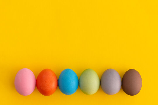 Colored eggs on a yellow background. Minimal easter concept.