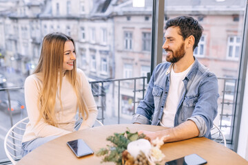 Happy millennial couple in love talking sitting at coffee house