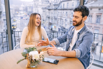 Happy millennial couple in love talking sitting at coffee house