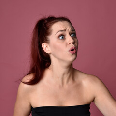Naklejka premium close up portrait of red haired women with different facial expressions on a pink studio background.