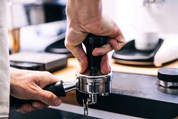 A man with a portafilter in his hands. The concept of making coffee in a coffee machine.