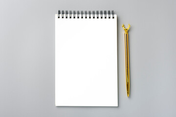 open notepad, golden pen on gray background, spiral notebook on table Business, planning, education, morning life working from home concept Top view Flat lay Mock up