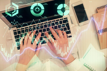 Double exposure of woman hands working on computer and forex chart hologram drawing. Top View. Financial analysis concept.