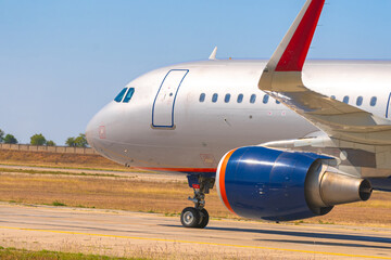 Big passenger airplane drives along the runway in airport