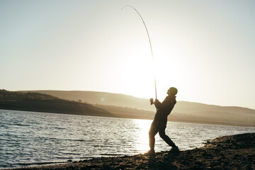 Fisherman with rod fishing on the lake