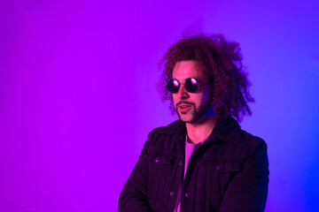 Portrait of an Afro-American hipster man, afro hair, in the style of the 80s and 90s, steampunk glasses, blue and purple neon lights. The modern trend of fashion.