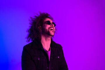 Portrait of an Afro-American hipster man, afro hair, in the style of the 80s and 90s, steampunk glasses, blue and purple neon lights. smiling and laughing