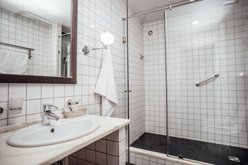 Modern bathroom interior. Shower room is covered with White and black tiles