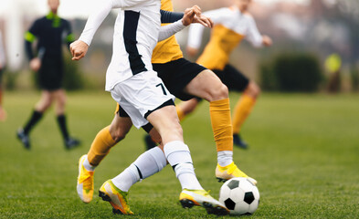 Adult sports players in football duel run. Footballers running ball at the game. Youth soccer league competition match
