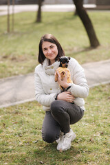 Prety woman with little pet outdoors. Woman walk with dog