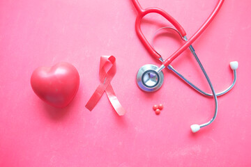 Red ribbon HIV, heart shape and stethoscope on red background.