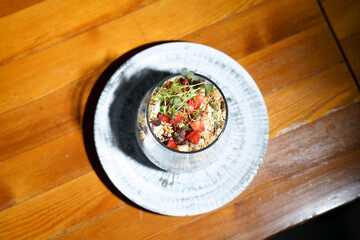 a dish in a restaurant, muesli with berries in a glass dish