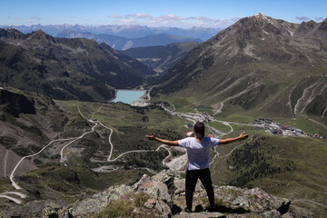 man defeated Neunerkogel (2604m) and rejoices in his victory. The climber enjoys views of the village of Kuhtai and the Langental Reservoir in western Austria. Feeling satisfied with hard work.