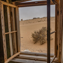 View out of a window at German Kolmanskop Ghost Town with the abandoned buildings in the Namib desert