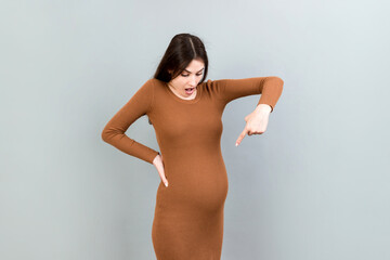 Fototapeta premium Young surprise or shocked woman pregnant isolated colored background. expression female