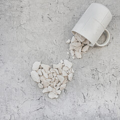 White chalk, many pieces are poured out of the mug and put in the heart. Food grade chalk. Writing chalk. - obrazy, fototapety, plakaty