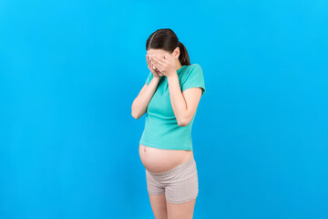 Fototapeta na wymiar Beautiful young pregnant woman feeling head ache on colored background isolated. Stressed pregnant woman or mother problems