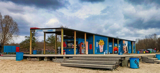 Moderner Strandimbiss mit bunten Graffitis am Cospudener See, Gastronomie am Sandstrand im Leipziger Neuseenland bei bewölktem Himmel, Markkleeberg, Sachsen, Deutschland