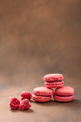 Macaroons. Raspberry Macaroons on a brown background. Pink and red Macaroons. French cake. Place for your text.