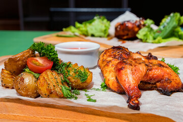 Juicy BBQ chicken leg quarters with fried potato. Food to go