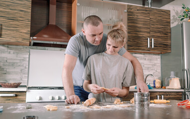 happy married couple makes cookies in the kitchen