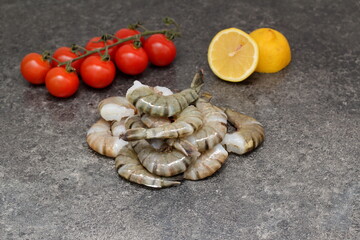 tiger prawns with tomatoes and lemon on the table