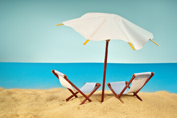 Beach umbrellas and sunbeds on the sand. Stylized cardboard beach. Paper umbrellas for cocktails in the background. The concept of rest, sea and vacation. Artificial wooden deck chairs.
