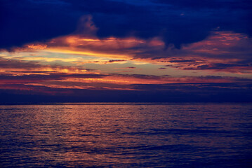Naklejka na ściany i meble Beautiful cloudy sky at dawn, calm sea water.