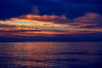 Obraz premium Beautiful cloudy sky at dawn, calm sea water.