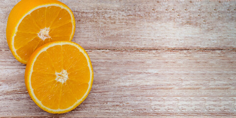 Orange halves on a wooden background.