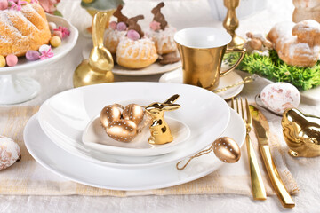 Easter table setting with golden color decors on the plate and cutlery
