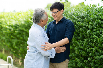 Obraz premium Senior Asian Father With Adult grown Son hugging outdoors