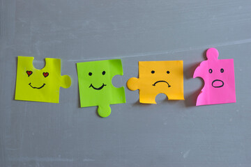 Different emotions drawn on paper puzzle notes.