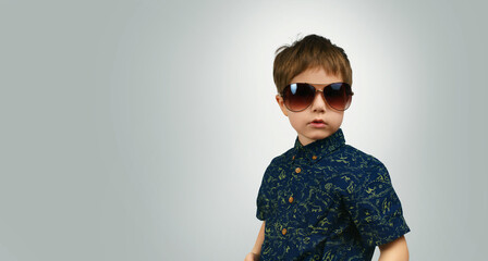 Serious little boy in sunglasses. Place for text