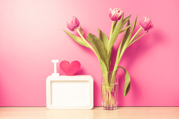 Fresh tulips flowers in glass vase on table