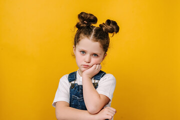 Serious pensive little kid girl looking unhappy at camera, tired upset preschool child with...