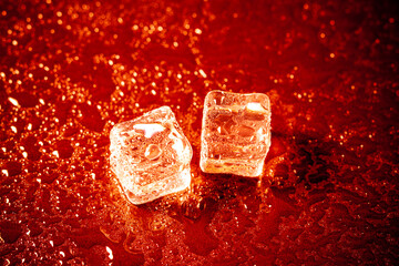 Red ice cubes reflection on black table background.