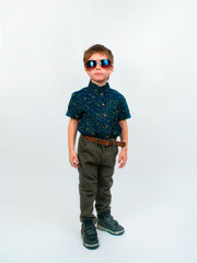 A little boy in trousers and a shirt. Photo in the studio on a white background