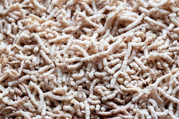 Close up of grind poultry meat. Photo taken under natural light shining through the window. Plastic shadows.