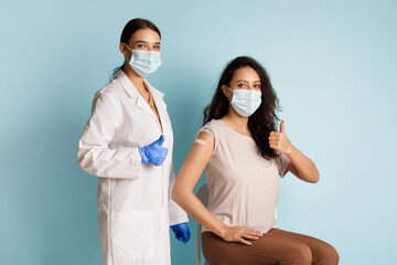 Female Doctor And Vaccinated Patient Gesturing Thumbs-Up Approving Vaccination, Studio