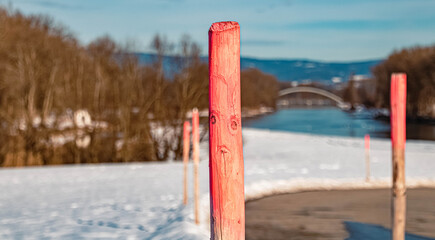 Beautiful winter landscape with details of wooden snow marker pylons near Plattling, Isar, Bavaria,...