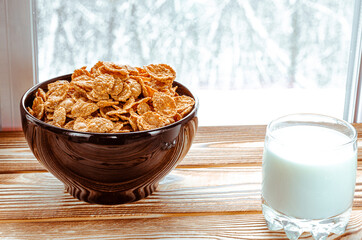 Morning breakfast. Cornflakes cereal and milk in a clay bowl