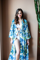Fototapeta premium Beautiful smiling woman in a light silk tunic for the beach