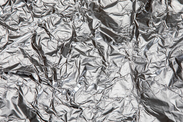Glossy, crumpled aluminum sheet. Packaging and protection. Abstract background