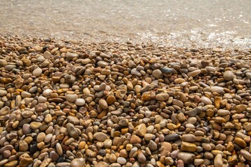 pile of washed up small stones on a beach in close up