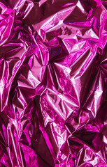 Crumpled pink foil. The background shimmers with rainbow colors.