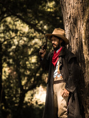 A senior cowboy standing with a gun to guard the safety of the camp in the western area