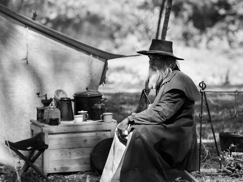 A Senior Cowboy Sat With A Gun To Guard The Safety Of The Camp In The Western Area